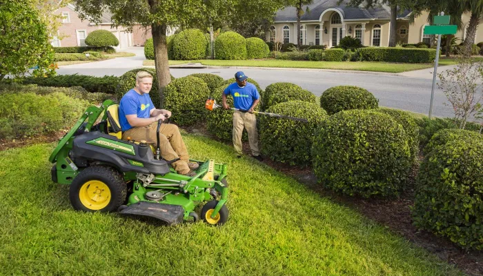 lawn maintenance technicians mowing and trimming landscape