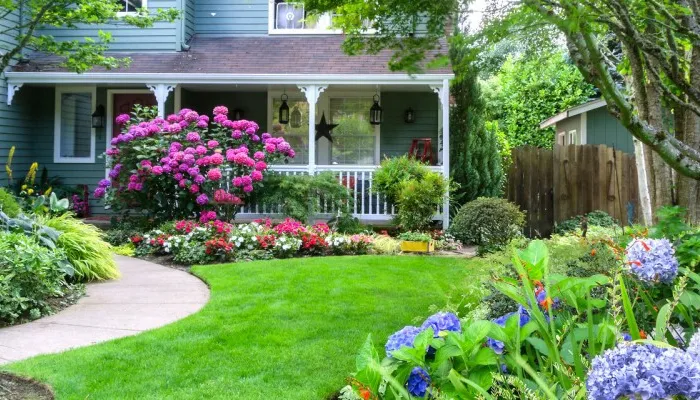 beautiful front yard landscape with green grass and flowers