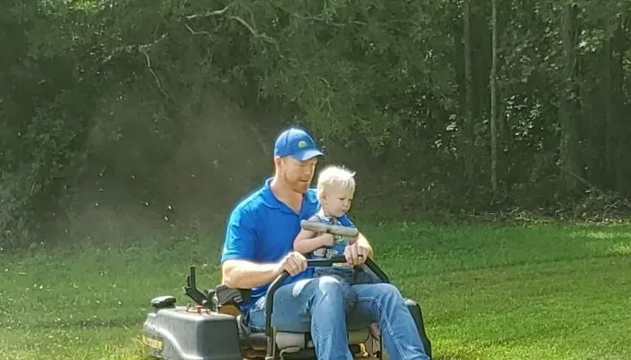 man and son on riding lawn mower