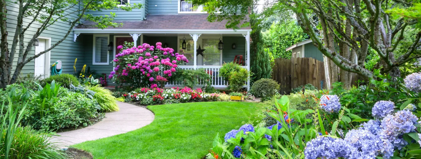 beautiful front yard landscape with green grass and flowers