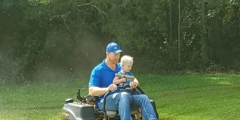 man and son on riding lawn mower