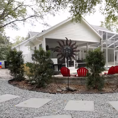 Completed backyard landscape design featuring a decorative stone pathway, seating area, and enhanced outdoor living space.