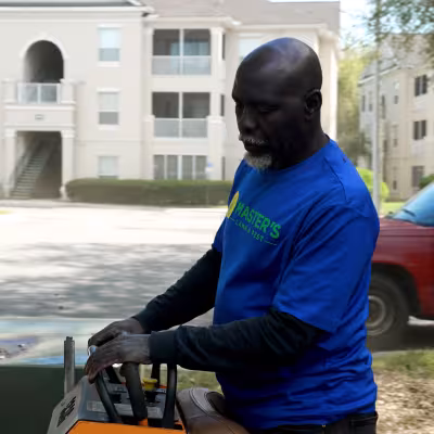 Landscape crew member performing routine grounds maintenance at a Gainesville condominium community.