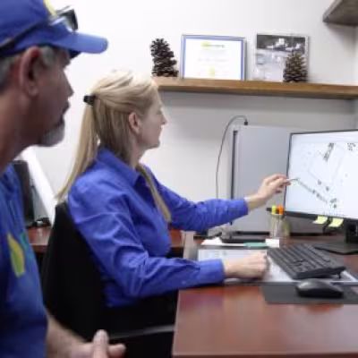 The Master's Lawn & Pest team reviewing an irrigation plan on a computer during the landscape renovation project.