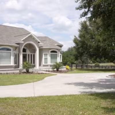 Completed front landscape renovation featuring a new lawn, refreshed planting beds, and landscaping surrounding the driveway and home.