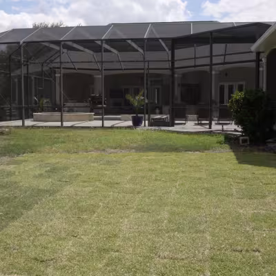 New sod installed around the backyard pool enclosure to restore the lawn surrounding the outdoor living area.