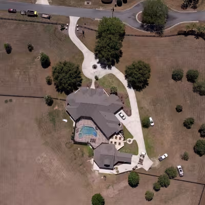 Aerial view of the property showing the home, surrounding acreage, and overall scope of the landscape transformation.