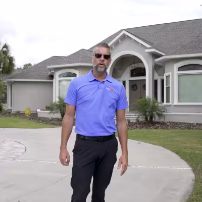 The Master’s Lawn & Pest team member standing in front of the home while discussing the landscape transformation.