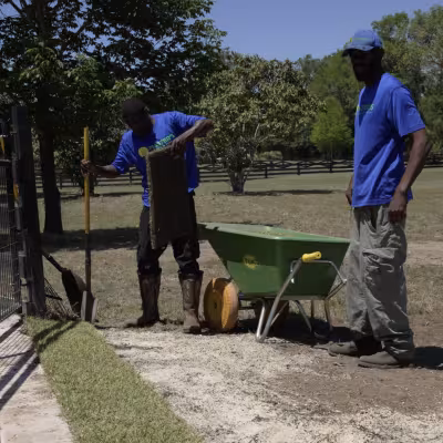 The Master’s Lawn & Pest installation crew laying new sod along the edge of the property.