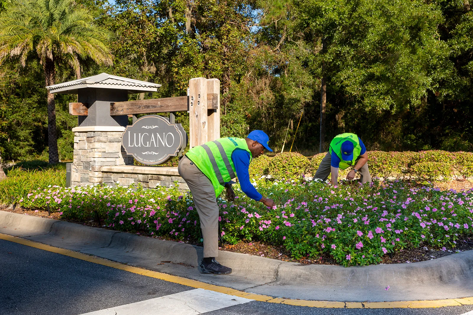 lawn maintenance technicians working in flower bed