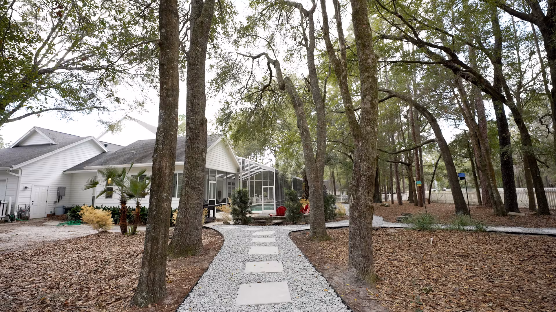 After photo of a landscaped backyard featuring a decorative stone pathway that connects the pool area with the rest of the outdoor living space.