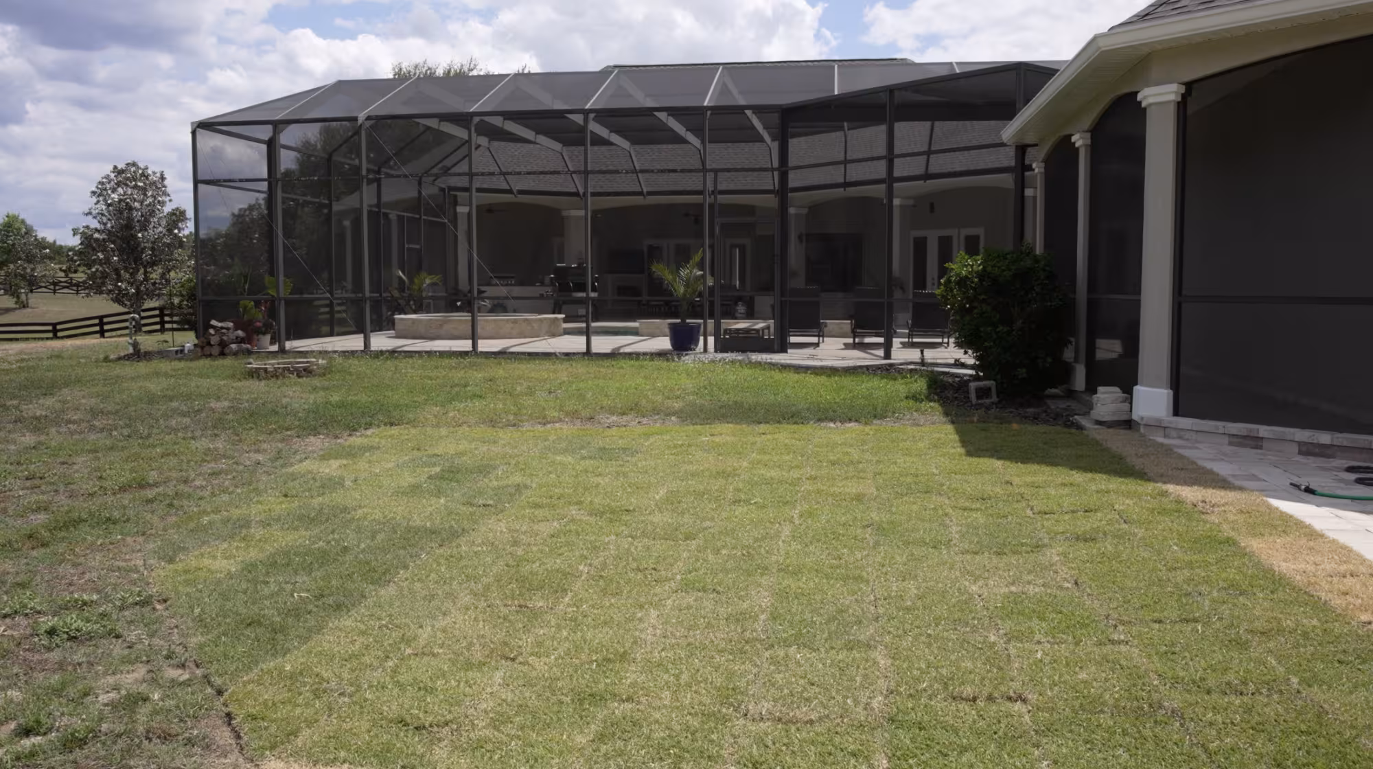 New sod installed around the backyard pool enclosure to restore the lawn surrounding the outdoor living area.